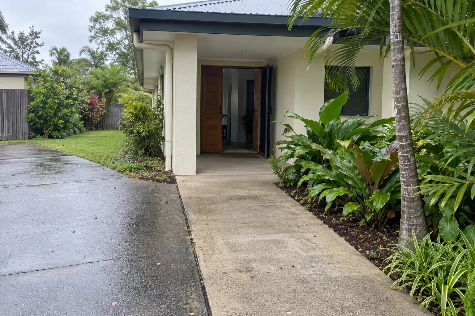 Clear concrete path leading to the covered entrance of a tropical Queensland home